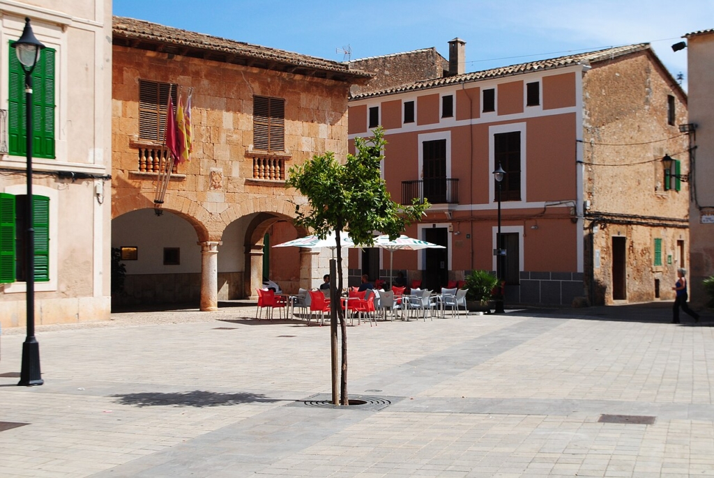 Plaça de la Vila i Santa Maria del Camí med rådhusets arkader og landsbyhuse.