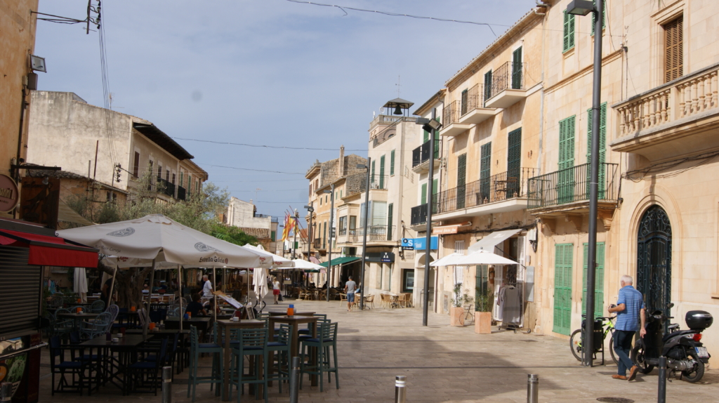 Die Plaça Major in Santanyí mit Natursteinhäusern und Caféterrassen.