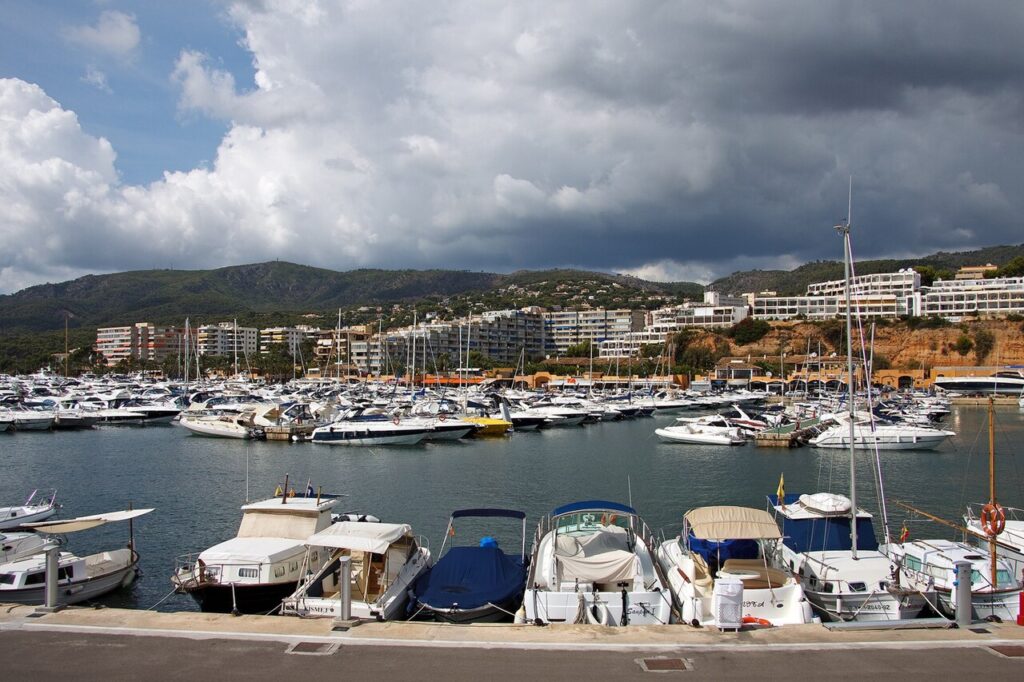 Boote an den Liegeplätzen im Yachthafen Puerto Portals unter bewölktem Himmel.
